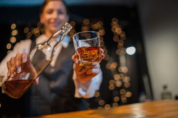 Barwoman pouring whiskey whiskey glass..