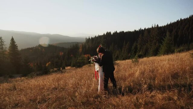 Authentic wedding couple walking through the mountains in autumn at sunset.Wedding concept in the mountains.Cinematic frame 4k