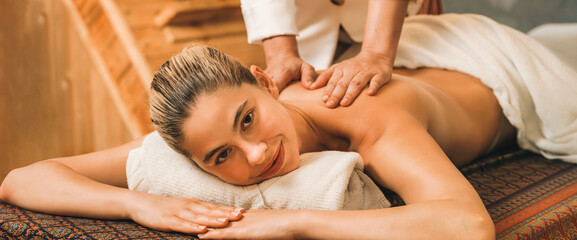 A portrait of a pretty girl having body massage while looking at camera with happiness in front of...