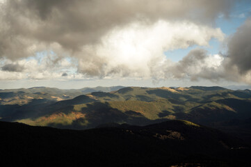 Golden autumn in the Carpathians. Mining arrays combined with trees with yellow leaves. Beautiful clouds and sun