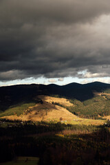 Golden autumn in the Carpathians. Mining arrays combined with trees with yellow leaves. Beautiful clouds and sun