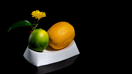 Composition with lemon and lime taking a bath on a black background