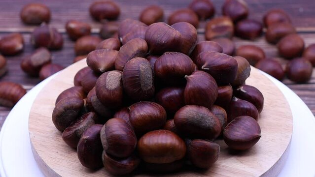 Fresh raw chestnuts rotating on a turntable.
