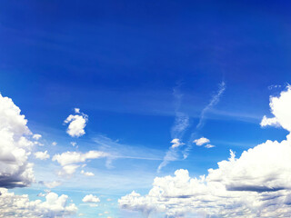 the landscape view is a white fluffy cloudy cloud and cumulus cloudscape with clear sunny weather and bright sunlight climate environment nature air on a blue beautiful wide high sky background