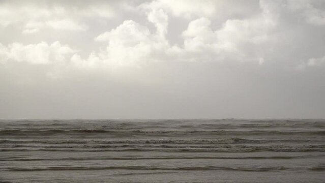 Thick and fast moving storm clouds pass over moody and threatening choppy waves whipped up by strong winds roll in before storm Ciar&aacute;n makes landfall.