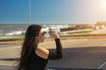 Girl Enjoying a Summer Drink with the Sea in the Background, with Copy Space