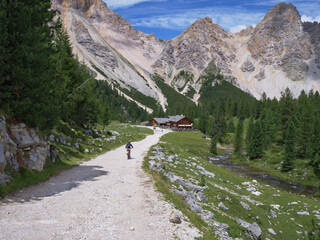 Tourist riding his Electric Mountain Bicycle on a Mountain Dirt Road in A Route Of The Alps, Italy