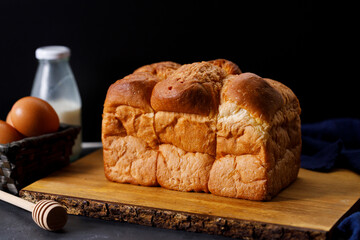 Closeup of soft white bread loaf on wooden table.