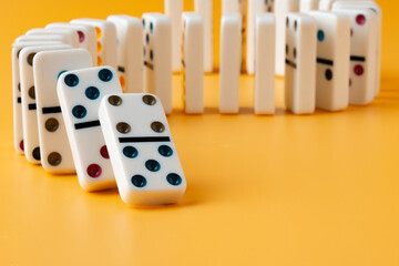 Row of domino tiles on yellow studio background