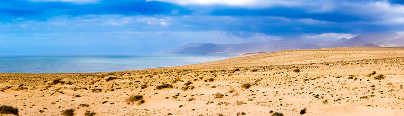 Fototapeta na wymiar panorama of a deserted island overlooking the sea, mountains and sand dunes