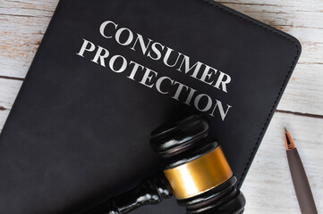 Top view of Consumer Protection text on black book with gavel background. Law concept