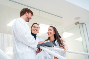 Obraz premium Young scientists talking and reading documents in a laboratory