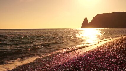 Sea beach horizon. Sea waves with soft, foamy waters washing multicolored pebbles on a beach during sunset. Nobody. Holiday recreation concept. Abstract nautical summer ocean sunset nature Slow motion