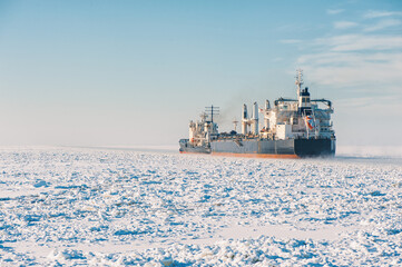 Winter shipping. Big cargo ships in ice sea fairway
