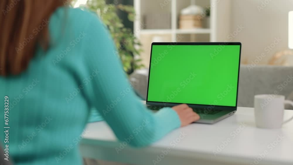 Poster close-up captures woman using laptop, focusing on hands as they type on keyboard while looks at comp