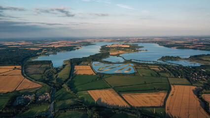Aerial view 4k of Rutland water in England during sunset in mid Summer.
