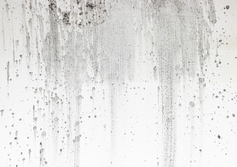 black splashes of paint on a white wall.