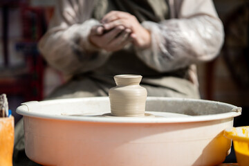 Fototapeta na wymiar master potter makes a clay pot on a potter's wheel made of clay