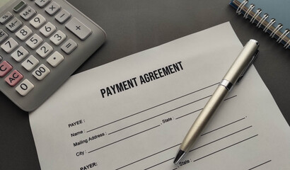 payment agreement form on the desk . Pen , calculator and notepad on the table