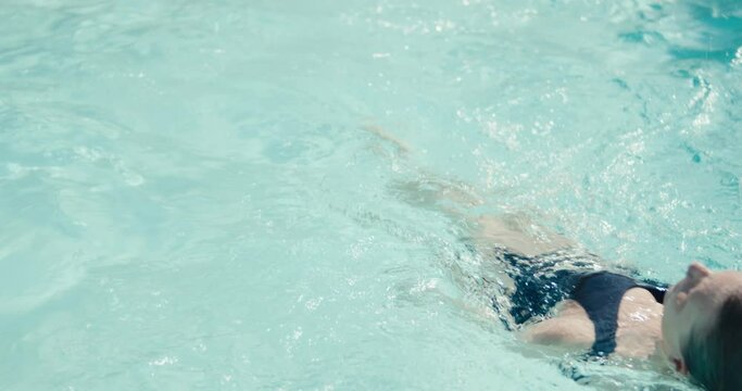 Woman swimmer backstroke swims swimming pool water swimsuit close up