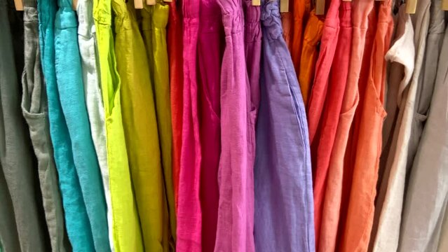 Multicolored fabric clothes in a textile shop close up.Shopping, industry, sale concept.Consumerism.