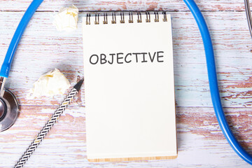 OBJECTIVE the text is written on a notebook that lies on old vintage boards