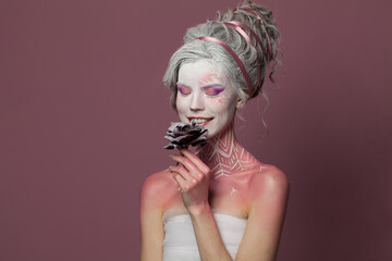 Joyful fashion model woman fantasy witch with stage makeup, studio portrait