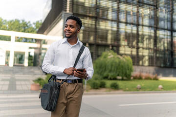 Dressed impeccably, the young African-American businessman walks briskly, multitasking with his...