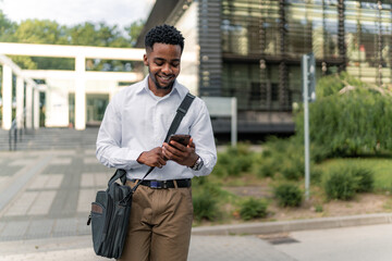 Dressed impeccably, the young African-American businessman walks briskly, multitasking with his...