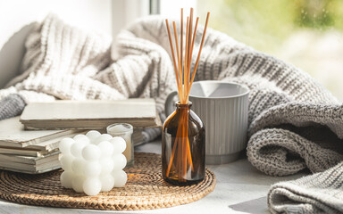 Composition with incense sticks, candles and books on the windowsill.