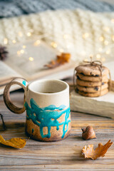 Cozy autumn composition with a handmade cup close-up.