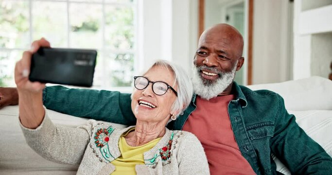Old couple on sofa with love, smile and selfie for memory, interracial marriage and bonding in home. Social media, mobile app and photography, happy senior man and woman relax on couch in living room
