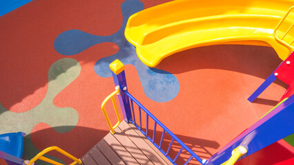 Colorful slide with outdoors playground equipment on rubber floor in kindergarten school, top view 