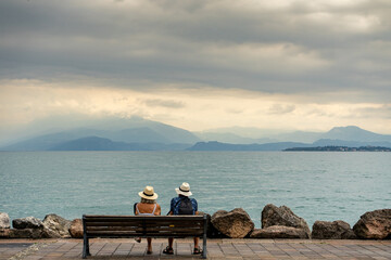 Old couple sitting on a bench on Lake Garda