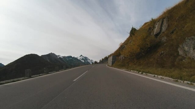 Car ride Point Of View, The Majestic Grossglockner Mountain Road in Austria, sharp peaks of the alpine mountains. POV shot of sport car or bicycle drives along the majestic and most beautiful mountain