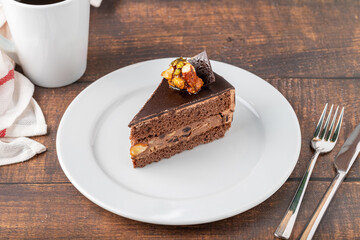 Delicious chocolate and pistachio cake on dark wooden background
