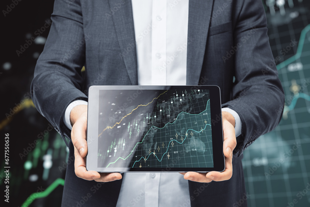 Poster close up of businessman hands using tablet with glowing candlestick forex chart on blurry dark backg