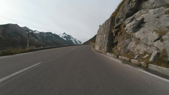 Car ride Point Of View, The Majestic Grossglockner Mountain Road in Austria, sharp peaks of the alpine mountains. POV shot of sport car or bicycle drives along the majestic and most beautiful mountain