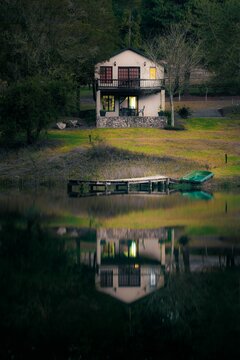 Lakeside house next to the calming waters of a lake at dusk.