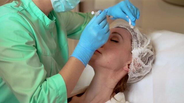 Procedure for tightening and smoothing wrinkles. Doctor cosmetologist makes Botulinum Toxin injection. Rejuvenating facial injections. Professional moisturizing and rejuvenating medical procedures for