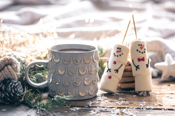 Winter composition with a cup of cocoa and marshmallow snowmen.