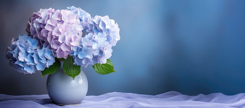 hydrangea flowers in vase on light blue pastel background