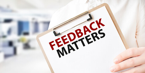 Text FEEDBACK MATTERS on white paper plate in businessman hands in office. Business concept - obrazy, fototapety, plakaty