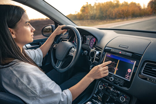 Woman using navigation system while driving a car.