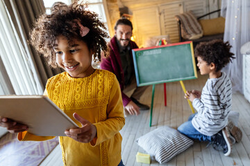 Happy multiethnic family. Single father having fun together at home with african american children.