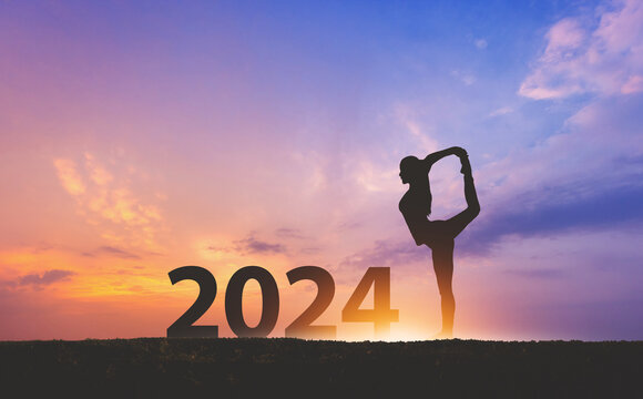 New year 2024 fitness healthy woman yoga with sunset sky background