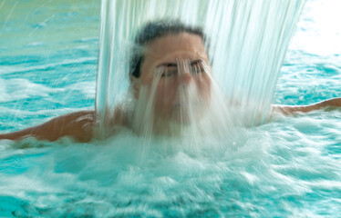 Woman Face Relax in a Hydromassage Pool with Falling Water in Long Exposure in Switzerland.