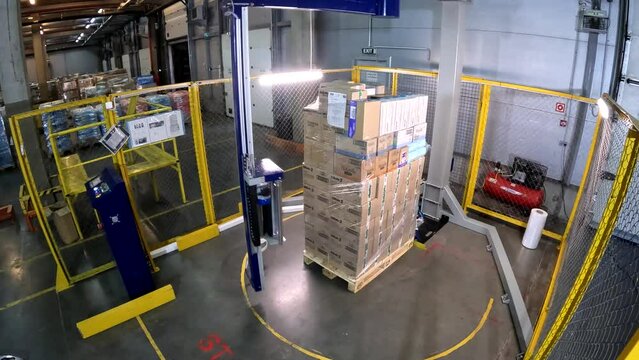Packaging boxes in plastic film at the factory. A special machine wraps boxes in polyethylene film