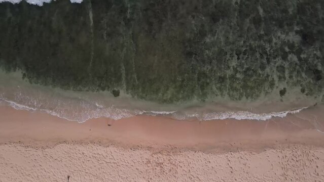 Aerial view seen from above, waves crashing on the white sand of Watu Karung beach, Pacitan, Indonesia