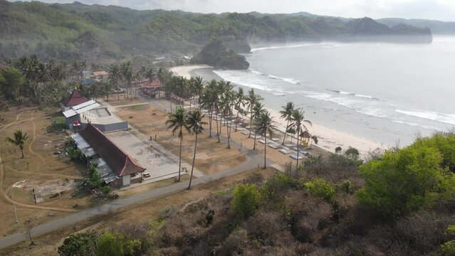 Beautiful morning aerial view of Klayar beach, Pacitan, Indonesia. You can see a gazebo and coconut trees.